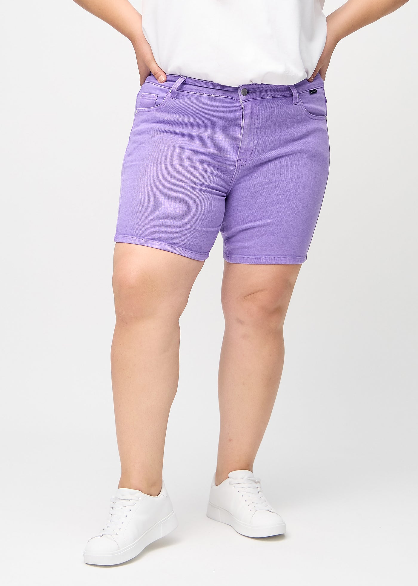 Lilla skinny short shorts, modelnavn Lavenders, som sidder tæt til, og slutter midt på låret på en plus-size model, set forfra.