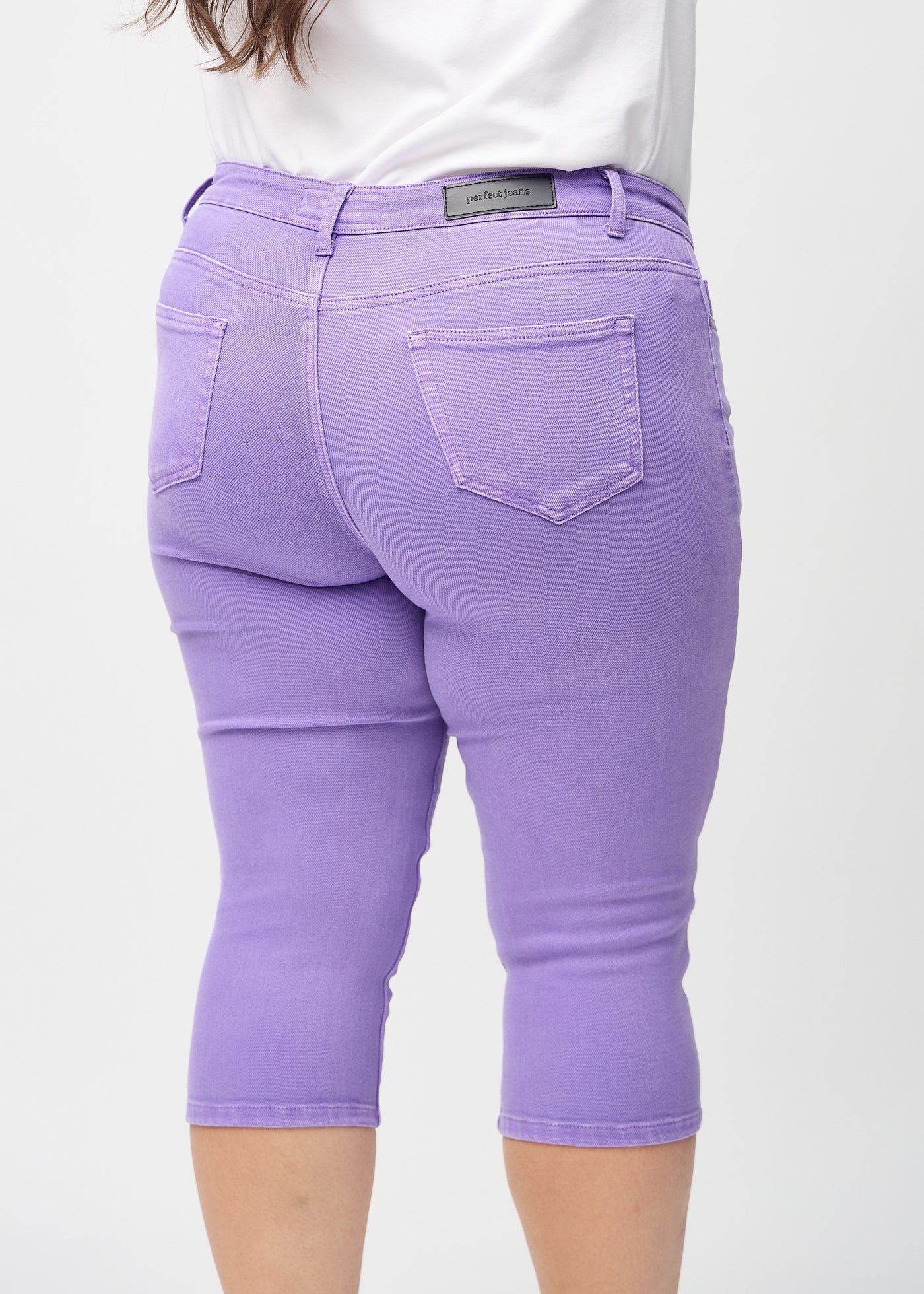 Lilla skinny capris set bagfra tæt på en plus-size model for at vise detaljer.