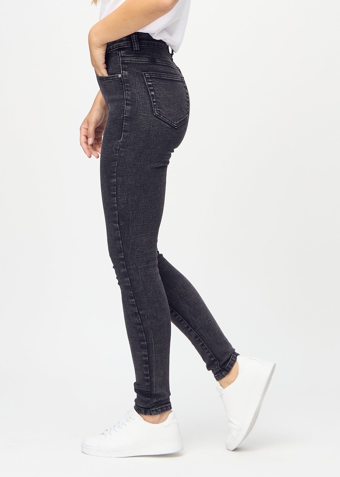 Mørkegrå denim skinny jeans set fra siden på model.